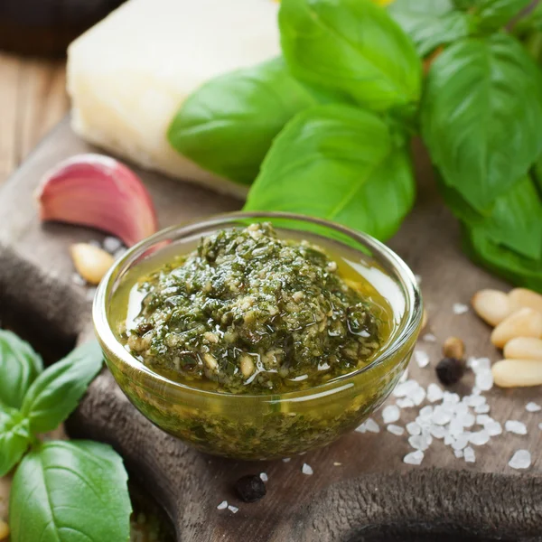 Homemade pesto on a rustic wooden cutting board. — Stock Photo, Image