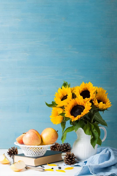 Букет подсолнухов в белой вазе с яблоками — стоковое фото