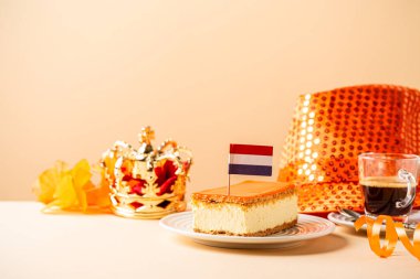 Tahta tahtanın üzerinde küçük bir Hollanda bayrağı olan kırmızı, beyaz ve mavi parçalarla kaplı portakallı tompet ve donut yığını. Ulusal Bayram Koningsdag 27 Nisan 'da Hollanda' da