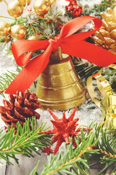 Golden bell with red ribbon bow and christmas decoration — Stock Photo, Image