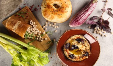 Doğu mutfağı. Humus. Nohut, tahin, zeytinyağı, limon ve kereviz kökü aperatifleri gri bir masada kahverengi bir kasede. Tandoor, patlıcan, fesleğen. Taşralı. Uzayı kopyala Flatlay, üst görünüm