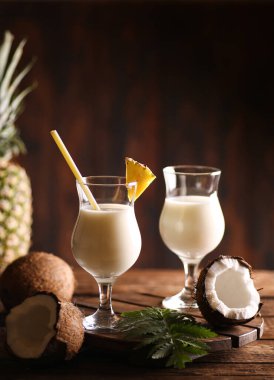 Alkolik kokteyl. Pina Colada. Ananas suyu, limon suyu, ahşap arka planda tropik yeşil yapraklı hindistan cevizi şurubu. Bar menüsü. Arkaplan resmi, alanı kopyala