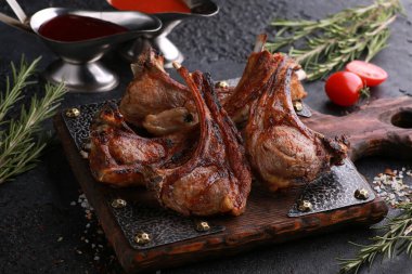 Izgarada et var. Domatesli, soslu, biberiyeli ve tuzlu, eski ahşap bir tahtada kuzu kaburgası. Restoran menüsü, arkaplan resmi, kopyalama alanı, yatay