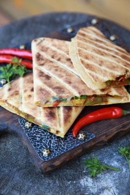 Meksika mutfağı. Tavuk ve sebzeli Quesadilla. Tahta masa üzerinde domates, soğan, et, domates, otlar, baharatlar ve kırmızı biberli tortilla. Arkaplan resmi, alanı kopyala