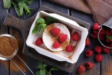 Sağlıklı yiyecekler. Teslimat için kahvaltı. Süzme peynir, taze ahududu, tarçın ve nane şekeri ahşap bir masanın üzerinde. Taşralı. Arkaplan resmi, alanı kopyala