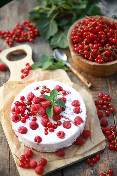 Summer atmosphere. Russian cuisine. Dacha, nature. Cottage cheese pie, cake with fresh berries: red currants and raspberries on an old wooden table. Background image, copy space