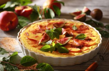 Yaz pastası. Nektarinli karamelli turta, incir ve arkaplanda nane şekeri. Dalında yeşil yapraklar olan taze meyve, güneşli bir gün. Taşralı. Arkaplan resmi, alanı kopyala