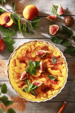 Yaz pastası. Nektarinli karamelli turta, incir ve arkaplanda nane şekeri. Dalında yeşil yapraklar olan taze meyve, güneşli bir gün. Taşralı. Arkaplan resmi, kopyalama alanı. Üst görünüm, düz görünüm