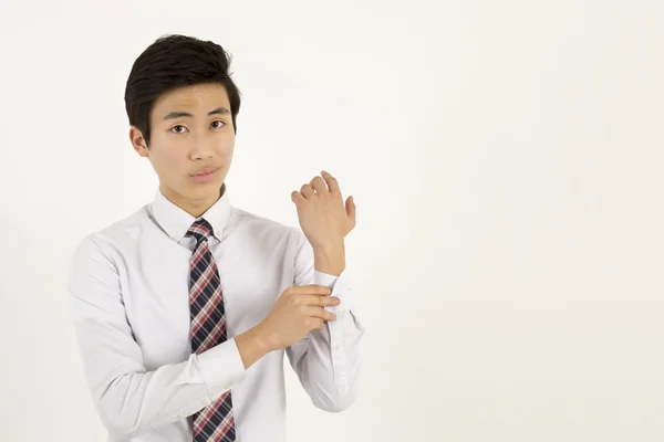 Азиатский молодой бизнесмен застегивает пуговицы на рукаве рубашки — стоковое фото