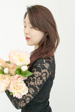 Bir buket çiçekli Asyalı kadın.