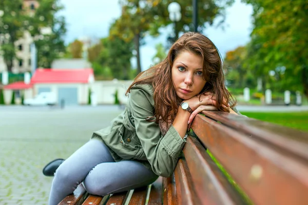 Kvinnan sitter på bänken — Stockfoto