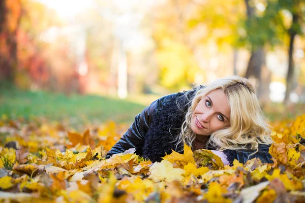 Vrouw liggen in de herfst park — Stockfoto