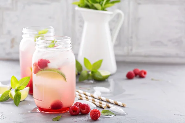 Cold green iced tea with lime and raspberry — Stock Photo, Image