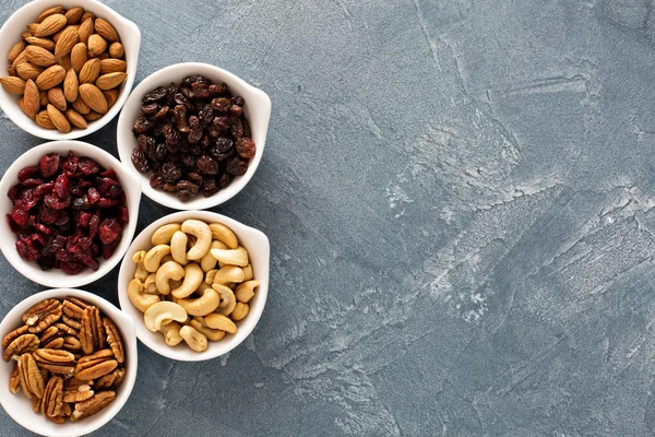 Разнообразие орехов и сухофруктов в небольших мисках — стоковое фото