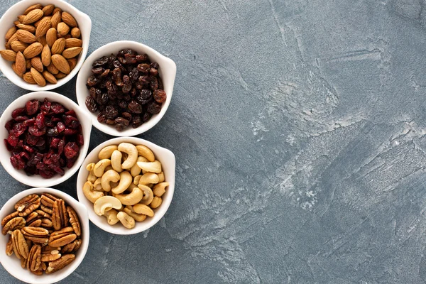 Variety of nuts and dried fruits in small bowls — Stock Photo, Image