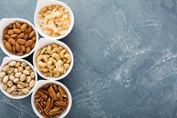Разнообразие орехов в маленьких мисках — стоковое фото