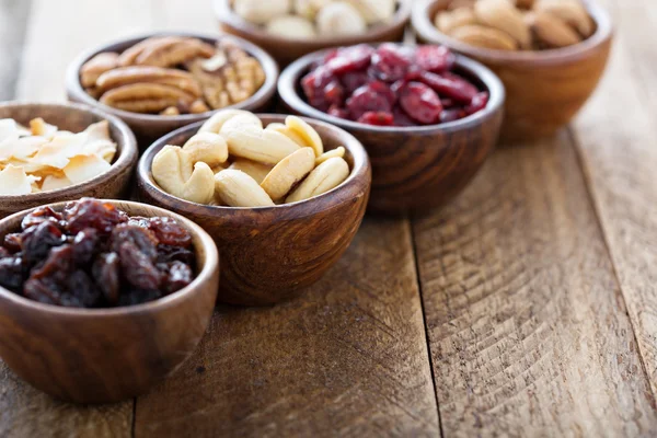 Variety of nuts and dried fruits in small bowls — Stock Photo, Image