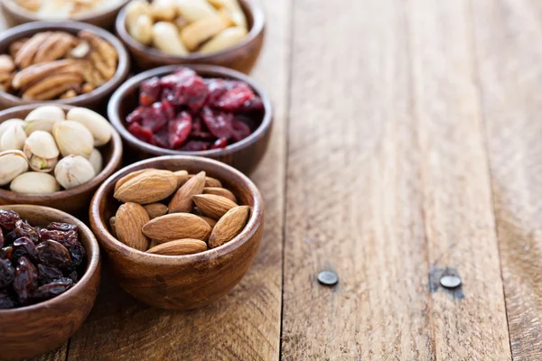 Variety of nuts and dried fruits in small bowls — Stock Photo, Image