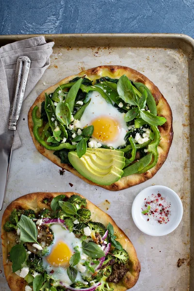 Breakfast pizza with baked egg and greens — Stock Photo, Image