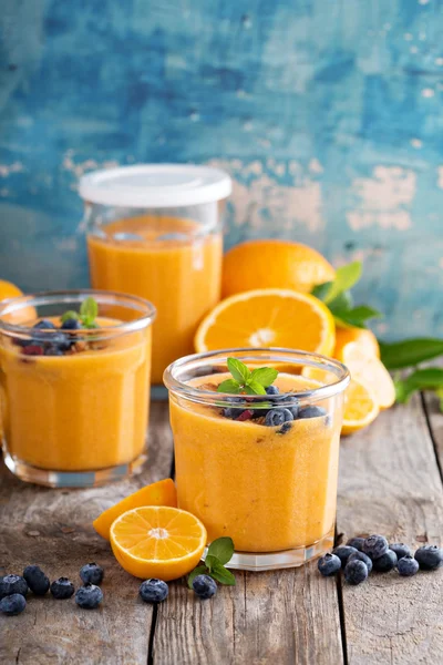 Orangen-Mango-Smoothie mit Müsli und Beeren — Stockfoto