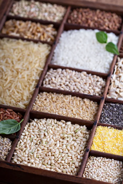 Variedade de grãos e sementes saudáveis em uma caixa de madeira — Fotografia de Stock