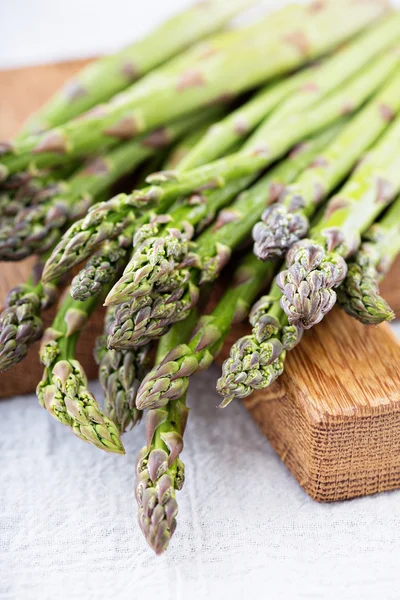 stock image Bunch of green asparagus on a board