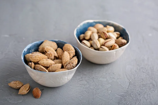 Gezouten amandelen en pimpernoten (pistaches) in een schelp — Stockfoto