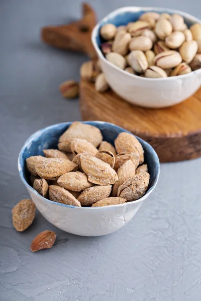 Gezouten amandelen en pimpernoten (pistaches) in een schelp — Stockfoto