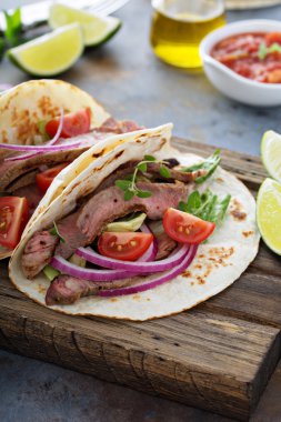 Biftek tacos dilimlenmiş karşılamak, salata ve domates salsa ile