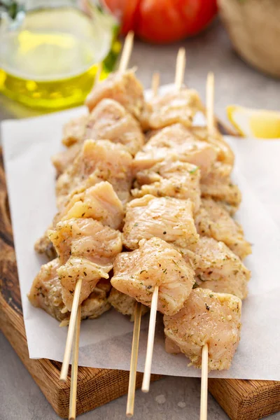 Brochetas de pollo crudas sobre papel pergamino —  Fotos de Stock