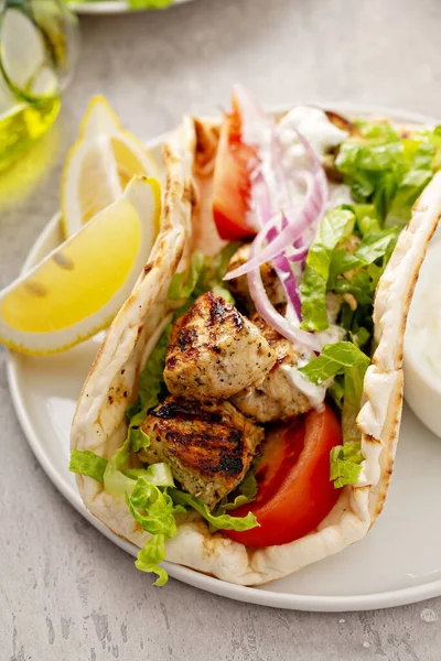Chicken souvlaki with fresh vegetables on a flatbread — Stock Photo, Image