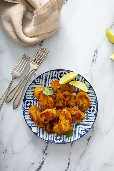 Plantains caramélisés frits servis avec des quartiers de lime — Photo