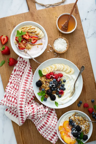 Olika yoghurt skålar med jordgubbar och vanlig yoghurt — Stockfoto