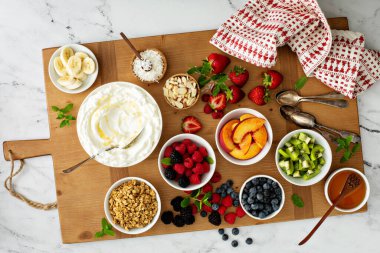 Yoğurt kasesi barı, farklı malzemelerle dolu büyük bir tahta.