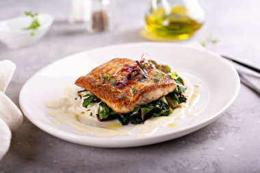 Yapraklı sebzeli sotelenmiş balık ve pilav.