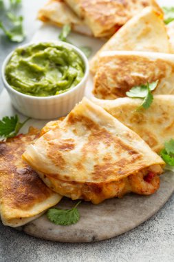 Guacamole ile servis edilen karides ve peynirli quesadilla.