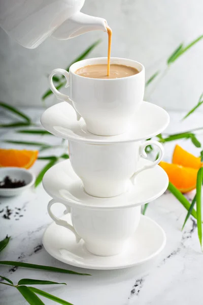 Earl γκρι τσάι γάλα χύνεται σε στοίβες φλιτζάνια — Φωτογραφία Αρχείου