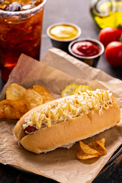 Hot dog with sauerkraut and mustard on parchment — стоковое фото
