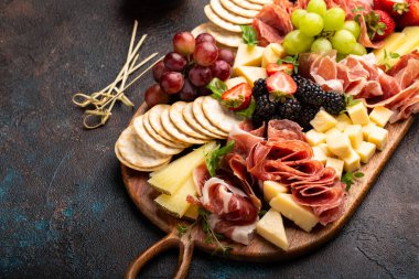 Koyu arkaplanda peynir ya da şarküteri tahtası