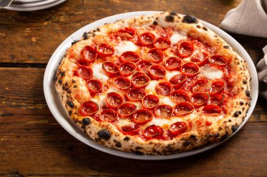 Taze pişmiş pepperonili ve mozzarella soslu Napoli pizzası.