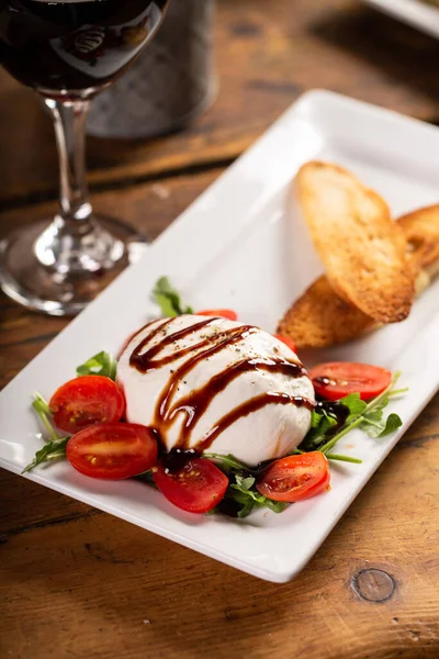 Italian appetizer plate with burrata and prosciutto — Stock Photo, Image