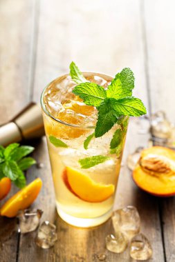 Taze nane, limon ve şeftali dilimli şeftalili mojito kokteyli.