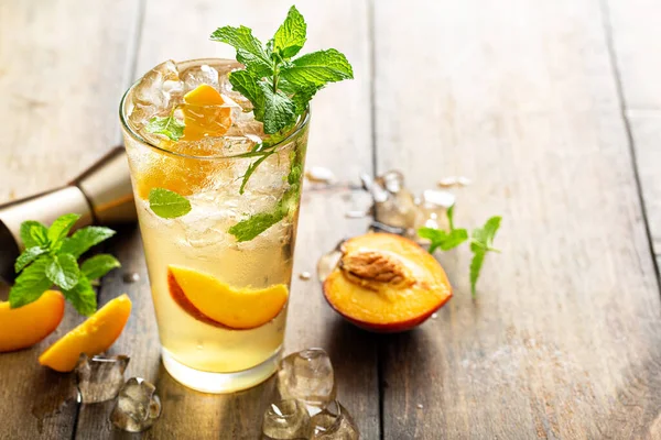 Літній персиковий коктейль мохіто зі свіжими шматочками м'яти, лайма та персика — стокове фото