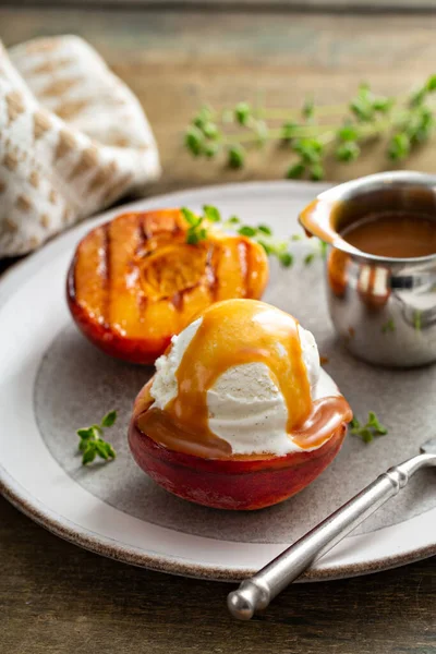 Pêssegos grelhados com sorvete e molho de caramelo, sobremesa de verão — Fotografia de Stock