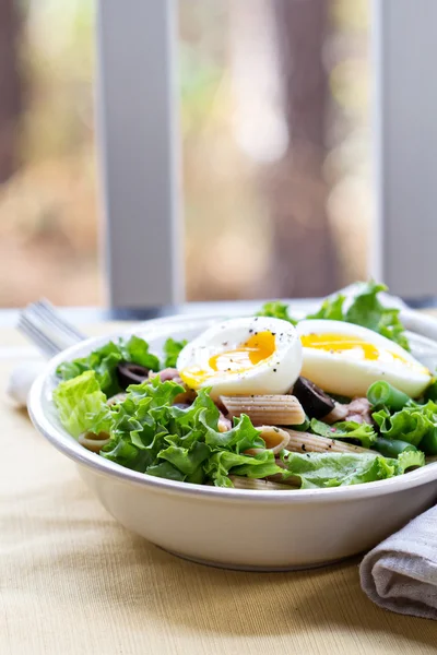 Салат с зеленью, макаронами, тунцом и яйцом — стоковое фото