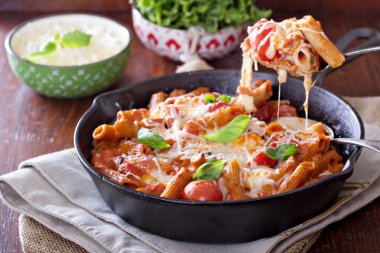 Pasta bake with penne, tomatoes and mozarella clipart
