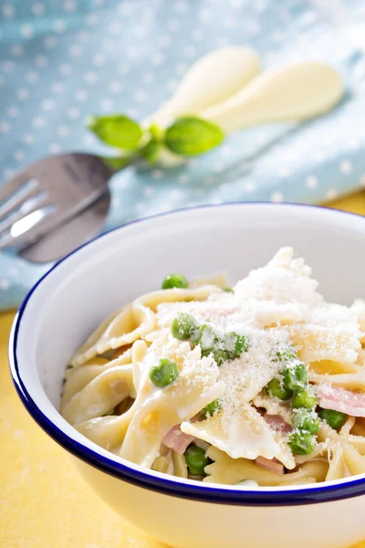 Bow ties pasta with ham and green peas — Stock Photo, Image