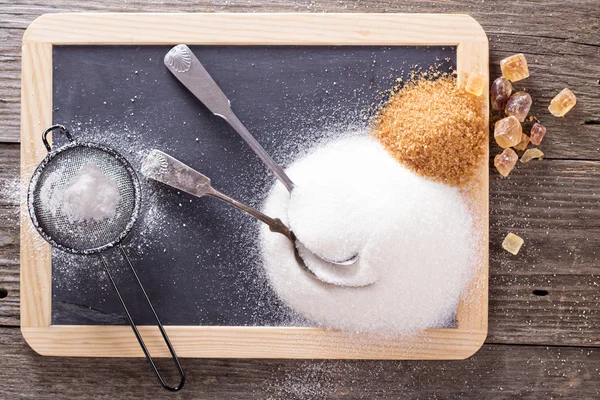 Variety of sugars on a chalkboard — Stock Photo, Image
