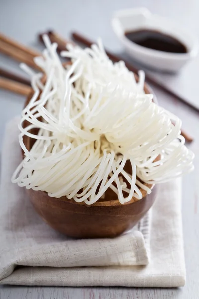 Fideos secos de arroz crudo en un tazón — Foto de Stock