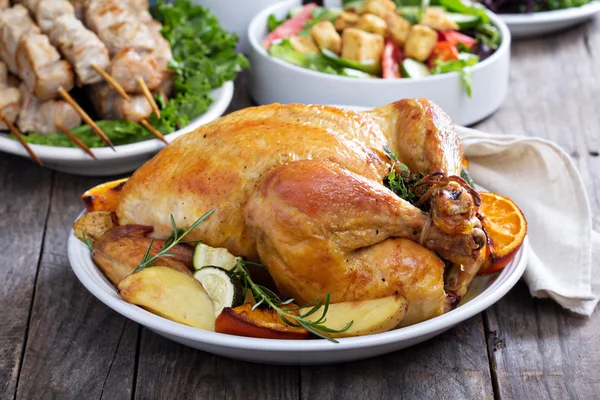 Whole roasted chicken on dinner table Royalty Free Stock Photos